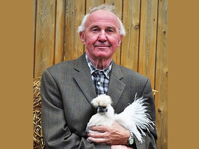 Älterer Herr mit einem Huhn